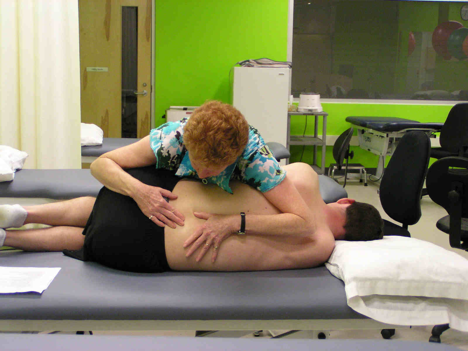 A woman is giving a man some massage.