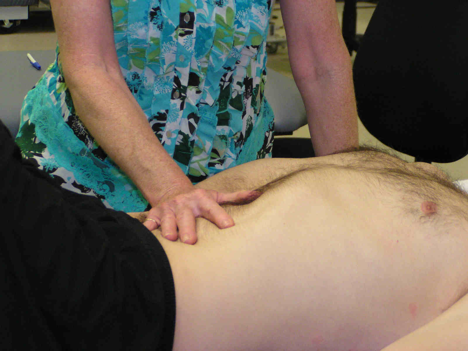 A person is getting their back examined by an osteopath.