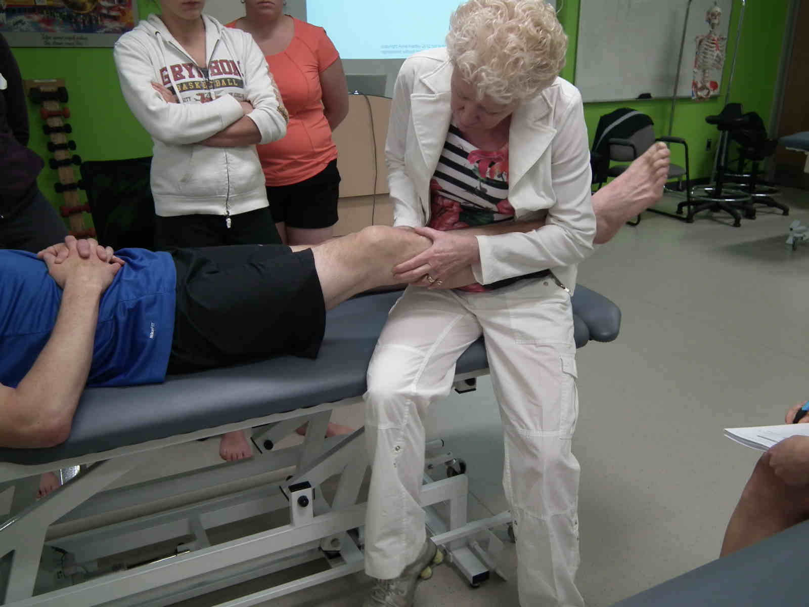 A woman is getting her foot examined by an older person.
